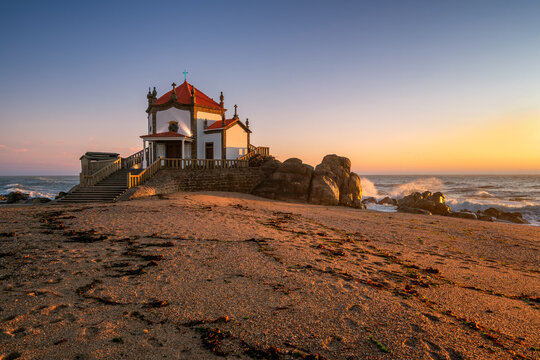 Beautiful chapel of Capela do Senhor da Pedra on the beach at sunset in Miramar, Vila Nova de Gaia, Portugal