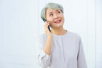 Senior Asia woman is talking on her mobile phone. Senior woman has a happy conversation at...