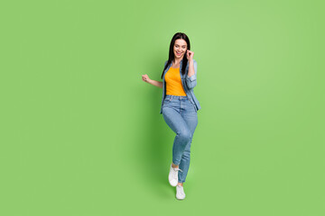 Full size photo of young pretty lovely smiling dreamy woman funky dancing enjoying weekend isolated on green color background