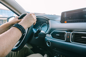 man hands on steering wheel