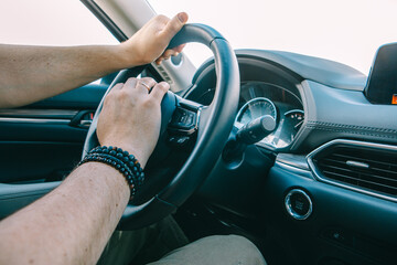 man hands on steering wheel