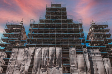 Restoration of the monument. Reconstruction and restoration of the old building. Metal scaffolding around a large and tall building at a construction site.