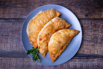 Chebureks with meat. Deep-fried flat pie. A traditional dish. Close-up, top view.