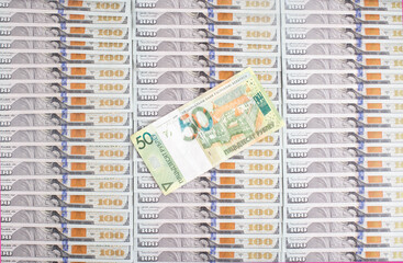 Banknote of 50 Belarusian rubles on the background of dollars. Concept of the ratio of the Belarusian ruble to the dollar currency, financial