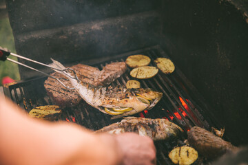 cooking fish and potatoes on grill