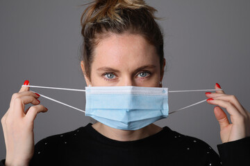 Young woman wearing surgical blue mask for corona virus. Pandemic.