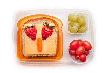 School lunch box snacks for kids over white background. Back to school. Healthy and fun snacks option for parents. Cute food art creative concepts. Bows with fruits and vegetables and cute sandwich.