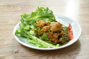 spicy fried chicken with chili and herb on lettuce in plate
