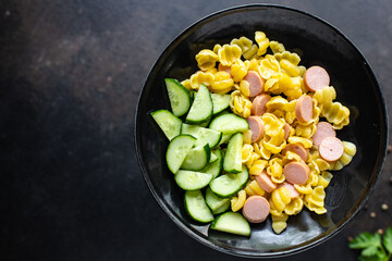 pasta sausages, cucumber salad vegetables, conchiglie menu on the table healthy food children's menu meal snack copy space food background rustic. top view