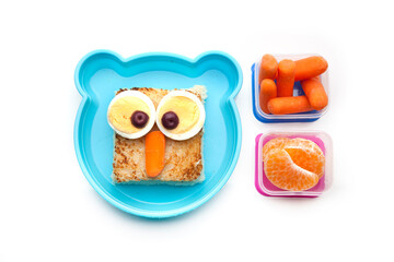 School lunch box snacks for kids over white background. Back to school. Healthy and fun snacks option for parents. Cute food art creative concepts. Bows with fruits and vegetables and cute sandwich.