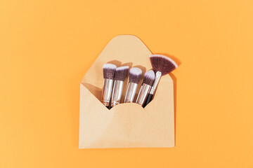 Set of makeup brushes in open paper envelope