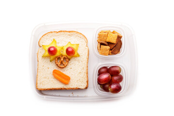 School lunch box snacks for kids over white background. Back to school. Healthy and fun snacks option for parents. Cute food art creative concepts. Bows with fruits and vegetables and cute sandwich.
