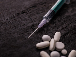 Syringe with medicine pill on textured background stock image.