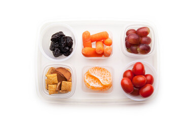 School lunch box snacks for kids over white background. Back to school. Healthy and fun snacks option for parents. Cute food art creative concepts. Bows with fruits and vegetables, top view.