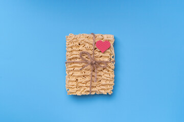 instant noodles, gift wrapped, tied with twine and bow. Top view