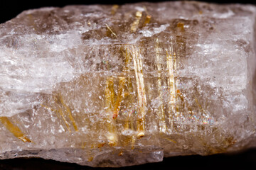Macro mineral stone Rutile in quartz on black background
