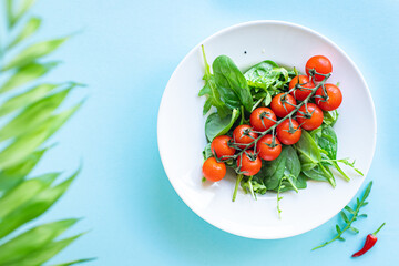 tomato salad cherry veggie green leaves fresh mix greens spinach, arugula, lettuce ingredient on the table healthy food meal copy space food background keto or paleo diet  