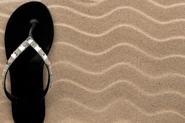 Sandy beach background with flip flops. Summer concept.