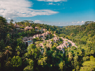 Fototapeta premium Aerial view of jungle with luxury resort on hill in Bali