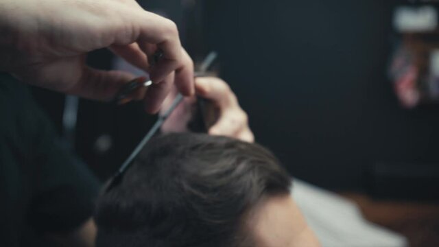 Close up view of barber cutting hair of man