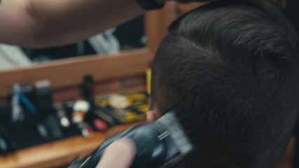 Close up view of barber using trimmer while working with client