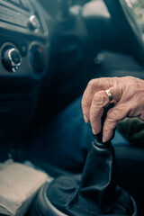 Old man changing gears in a car. Gear knob - Gear shifter. 