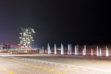 Wasserfontänen Nachts mit fliegenden Regenschirmen