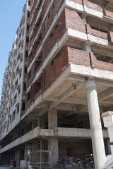 Building under construction against blue sky. General view of the construction of a new residential complex. Partially constructed Multi-storey buildings and high-rises. Mumbai India May 2020
