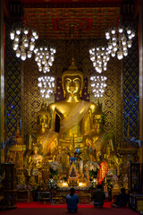Fototapeta na wymiar Three golden Buddha statues in lamphun, Thailand
