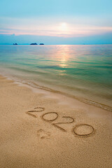  Beach ocean wave with handwritten numbers and footprints on the sand.