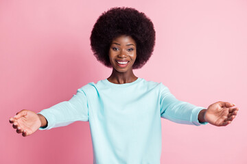 Photo of happy pretty afro american woman open hands you welcome isolated on pastel pink color background