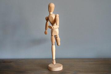 Wooden mannequin figure running towards you