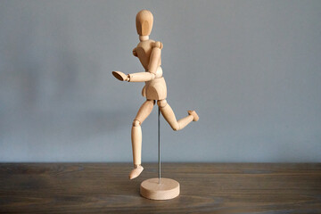 Wooden mannequin figure running head-on