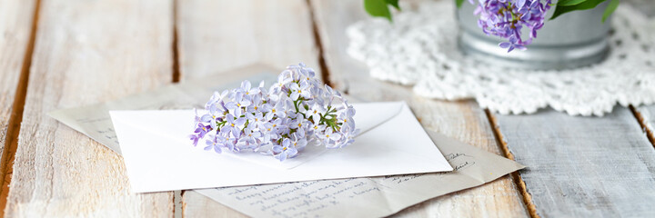 Beautiful fresh violet lilac bouquet in metal can. Greeting card for Birthday, Mother's day, Saint Valentine's Day, 8 march, Women's day. White wooden background banner with copy space for text