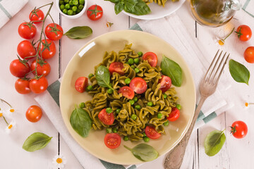 Fusilli pasta with cherry tomatoes and peas.