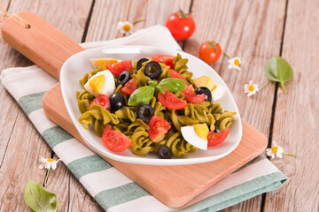 Fusilli pasta with cherry tomatoes, eggs and black olives.