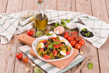 Fusilli pasta with cherry tomatoes, eggs and black olives.