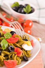 Fusilli pasta with cherry tomatoes, eggs and black olives.