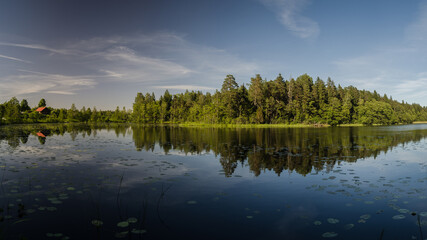 Beautiful evening view with lake, reflections in the water and clouds.