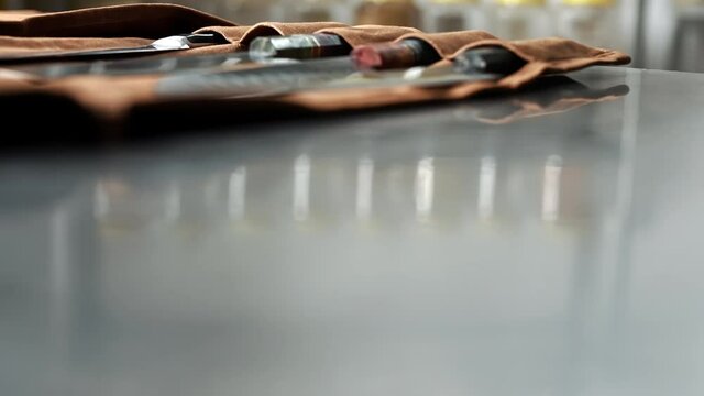 Chef takes out a knife from a leather roll,then puts it back,knife set.
