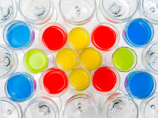 Background of glasses with colored liquid viewed from above 