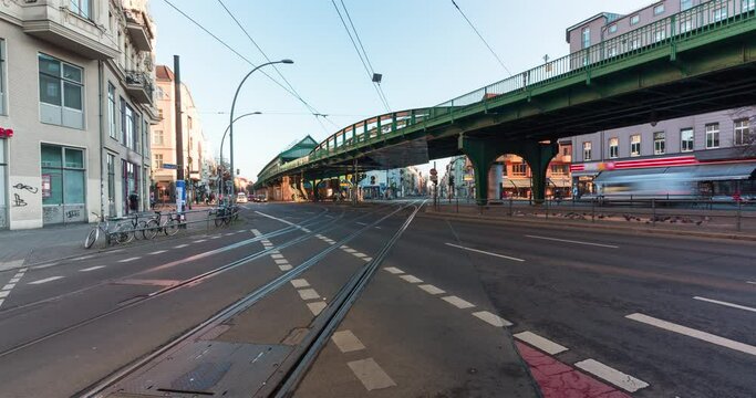 Timelapse of a busy intersection in central Berlin. City street with cars, people, trams and trains moving on a clear morning.