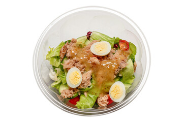 Fresh tuna salad with lettuce, cucombers, cherries and eggs in plastic container.