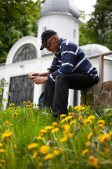 Latino american man resting on church background among blooming dandelions