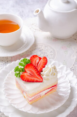 Obraz na płótnie Canvas Homemade Strawberry Shortcake with Strawberry Sauce Filling on White Dish and Hot Tea Serve.