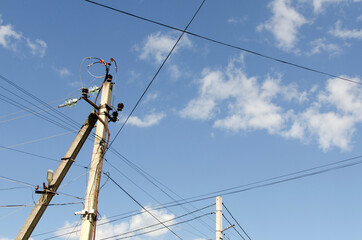 Electric pole with wires against the blue sky