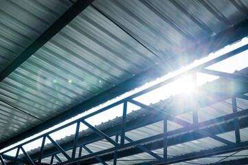 Sunlight shining through metal sheet roof on parking lot