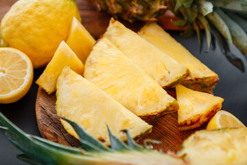 Pineapple on cutting board. Summer tropical fruit Sliced pineapple slicing cooking process in kitchen on dark background