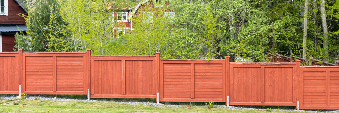 Traditional Swedish red wood fence. Typical red coloring of houses and fences in Scandinavia in old traditions. Header.