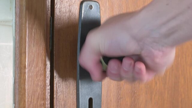 Locked door, trying to open the door. Pulling and turning the door handle trying to open the door.